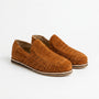 Pair of terracotta brown woven suede huarache slip-on shoes with flat soles on a white background.